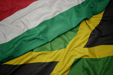 Obraz premium waving colorful flag of jamaica and national flag of hungary.