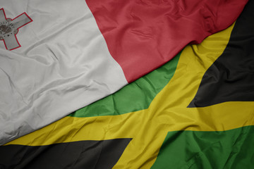 waving colorful flag of jamaica and national flag of malta.