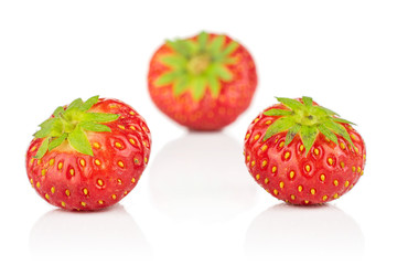 Group of three whole fresh red strawberry isolated on white background