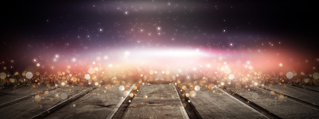 Dark room with a wooden table. In the background, neon background, old brick, spotlights. Abstract interior. Empty night scene.