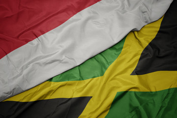 waving colorful flag of jamaica and national flag of indonesia.
