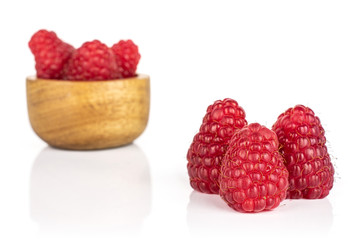 Group of six whole fresh red raspberry in tiny wooden bowl isolated on white background