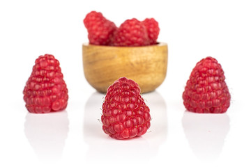 Group of six whole fresh red raspberry in tiny wooden bowl isolated on white background