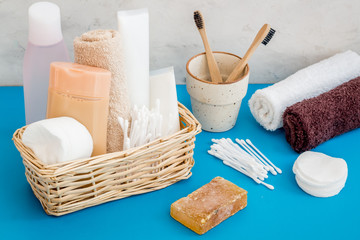 Bathroom accessories set with tooth brushes and towels on blue background