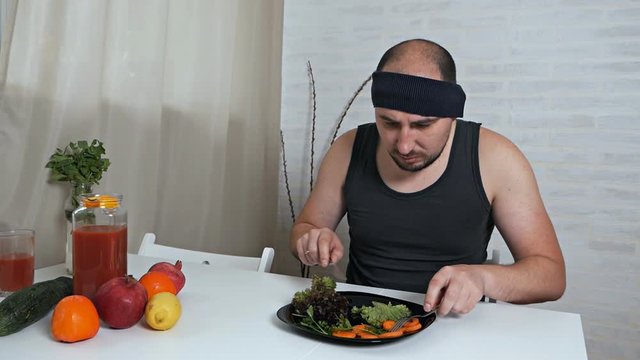 Fat man refuses to eat healthy food. Diet concept. Man hates vegetarian diet
