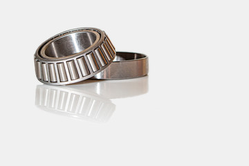 Angular contact bearing on a white background with reflection, consisting of two parts.