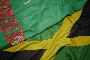 waving colorful flag of jamaica and national flag of turkmenistan.