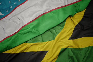 waving colorful flag of jamaica and national flag of uzbekistan.