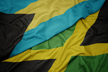 waving colorful flag of jamaica and national flag of bahamas.