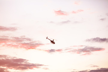 Helicopter against the morning sky, some scattered clouds, emergency mission in progress; aerial vehicle concept.