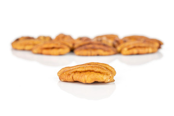 Lot of whole dry brown pecan nut one is in the front isolated on white background