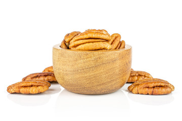 Lot of whole dry brown pecan nut in tiny wooden bowl isolated on white background