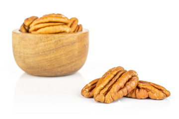 Lot of whole dry brown pecan nut in tiny wooden bowl isolated on white background