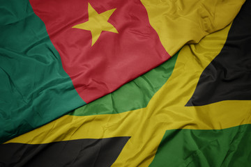 waving colorful flag of jamaica and national flag of cameroon.