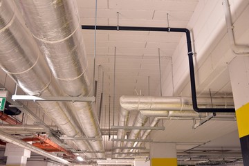 Water pipes and cable trays run under ceiling of a building