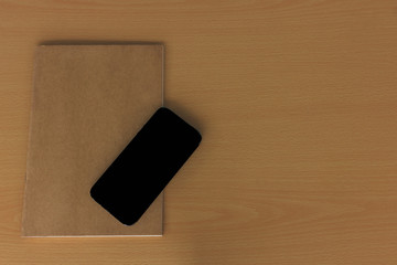 Note book with smart phone on wood table
