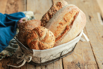 Bread in a basket on a black background. Assorted baking in a metal basket. Place for recipe and...