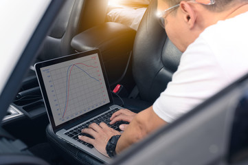 Auto mechanic (ECU tuning) with a notebook computer.