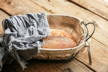 Bread in a basket on a black background. Assorted baking in a metal basket. Place for recipe and text. Background with rolling pin and flour. Rye bread and baguette with seeds. Buckwheat bread 