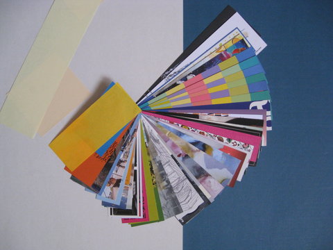 Separadores, punteros o marcap&aacute;ginas de colores combinados en forma de abanico o media espiral sobre fondo blanco y azul con  otros papeles de colores para hacer marcap&aacute;ginas