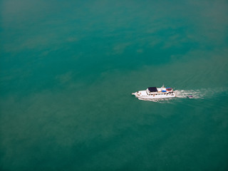 Aerial view of the speedboat and a boat behind it sailing near the coast of Thailand, white trace on the water; vessels concept.