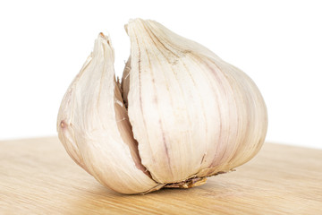 One whole aromatic white garlic on bamboo cutting board isolated on white background
