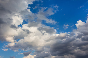 White and gray curly clouds in the blue sky_