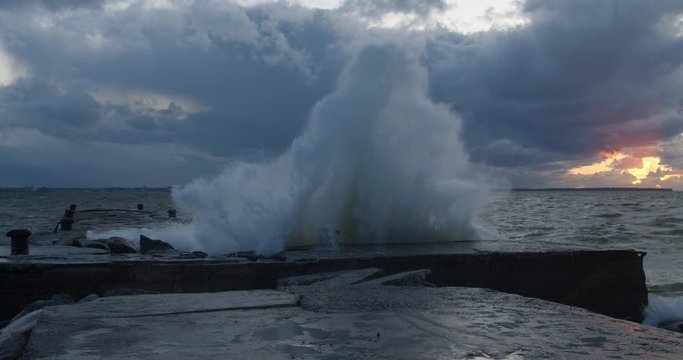 Big storm waves crashing to pier resulting high spray water cascade