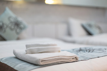White towel on bed in guest room for hotel customer.