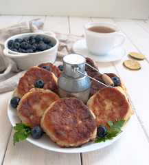 cheesecakes on a plate with a can of milk and blueberries