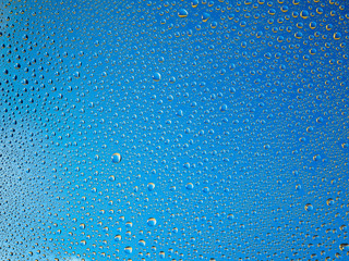 Water droplets on the glass with a colored background. Drops of water.