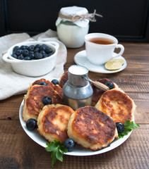 cheesecakes on a plate with tea milk and blueberries