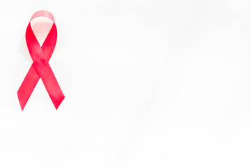 Pink ribbon as symbol of breast cancer awareness on white background top view copy space
