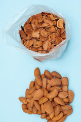 Fresh healthy tasty nutritious almond on light blue background. Top view. Flat layout. vertical orientation.