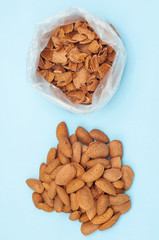 Fresh healthy tasty nutritious almond on light blue background. Top view. Flat layout. vertical orientation.