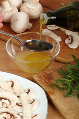 Pouring olive oil into small mixing bowl with juice of lemon. Making sauce for carpaccio. 