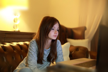 Teen girl using laptop, surfing the internet, doing homework and studying