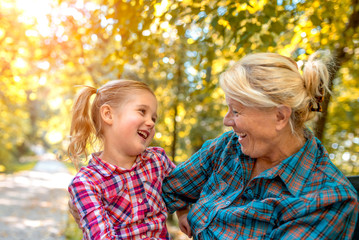 Grandmother and granddaughter hugging and enjoying in park