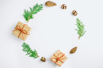 Eco Christmas composition with christmas gift in craft paper, dried orange, cypress cones and thuja branches on white background. Flat lay, top view
