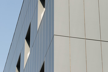 Geometric colored building facade elements with planes, lines and corners with light flare and reflections for an abstract background and texture of white, blue, gray colors. Place for text
