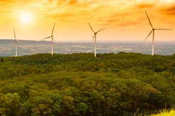 Fototapeta na wymiar concept idea eco power energy. wind turbine on hill with sunset