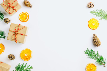 Eco Christmas composition with christmas gift in craft paper, dried orange, cypress cones and thuja...