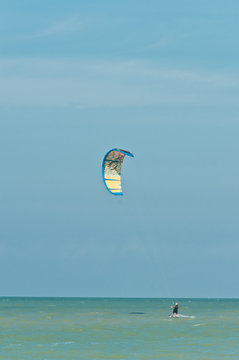 Front, bottom view, log distance of a the colorful canopy of a kite board, filled with tropical breeze, on a sunny, winter day