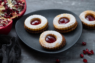 cookies with jam and pomegranate on ceramic background