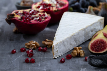 figs with cheese and pomegranate on ceramic background