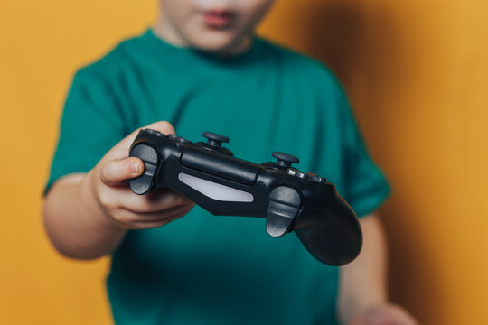 small boy with joystick on yellow background