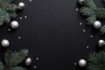 Black christmas banner mockup with fir tree branches, silver balls, confetti. Christmas frame, greeting card template, web banner mockup. Flat lay, top view, copy space