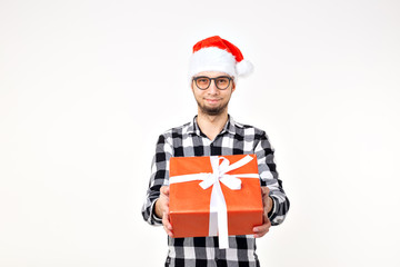 Holidays and presents concept - Funny man in Christmas hat holding gift box on white background
