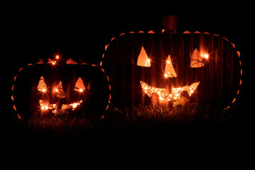 Two Jack O Lantern Pumpkin Lanterns Glowing in the Dark.