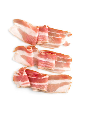 A slice of bacon on a white background. Three raw bacon close up on a white background. Top view.